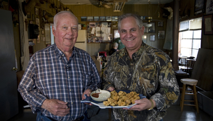 Chef John Folse with a plate of Cajun fried alligator